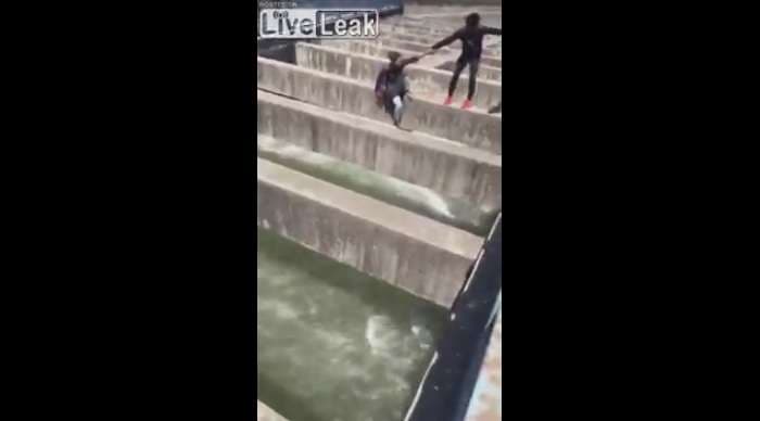 Gruaja bie në lumin e rrëmbyeshëm (VIDEO)