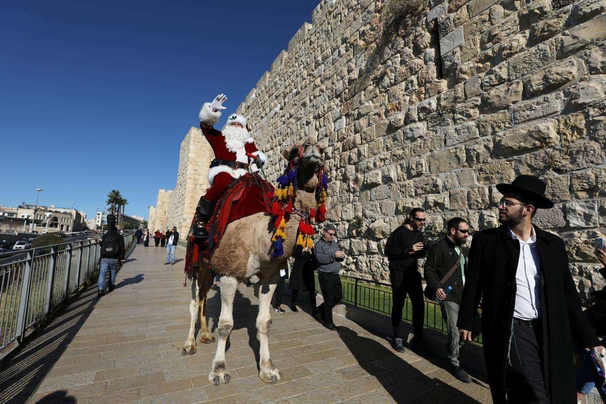 Babadimri hipur mbi deve dhuron drunj të Krishtlindjeve nëpër Jerusalem